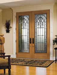 A living room with stained glass doors and a rug.