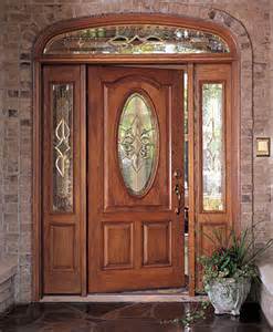 A wooden door with a stained glass window is sitting in front of a brick wall.