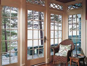 A living room with a chair and a table and a lot of windows.