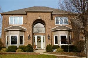 A large brick house with a lot of windows and a tree in front of it.