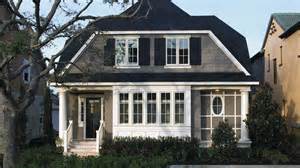 A large house with a large porch and a black roof.