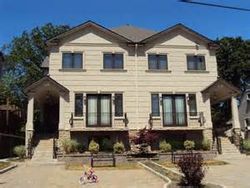 A large house with a lot of windows and a bicycle in front of it.