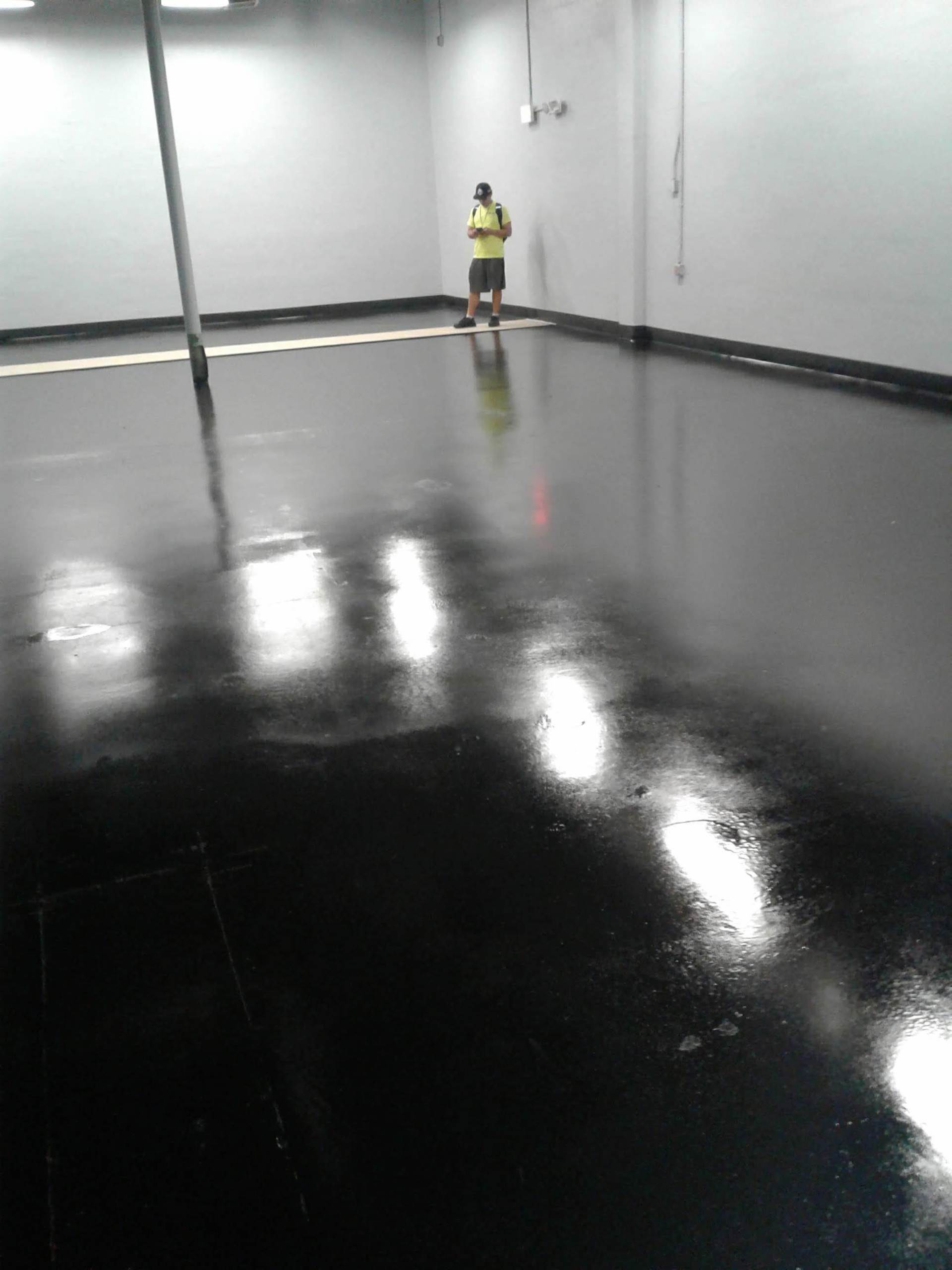Empty glossy room with a person in a yellow shirt standing near the back wall