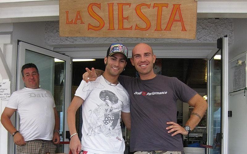 un ragazzo accanto a Mattia Pasini pilota di Moto Gp in posa per una foto