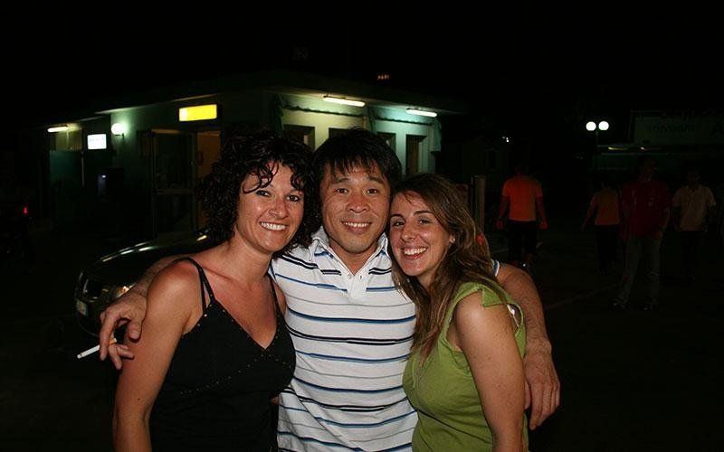 un ragazzo asiatico e accanto due ragazze in posa per una foto 