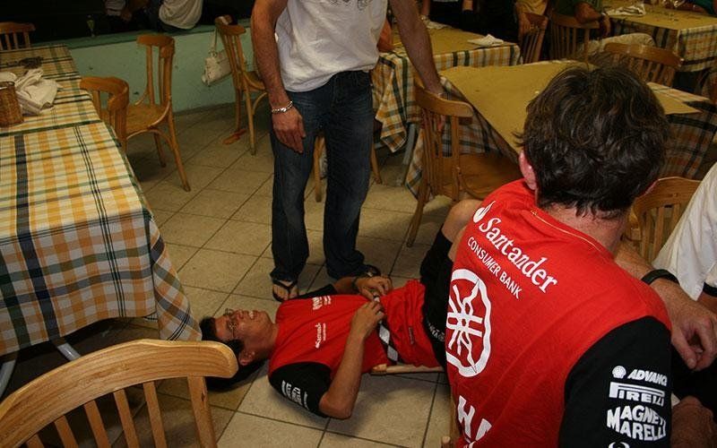 un ragazzo con una maglietta rossa sdraiato per terra in un ristorante