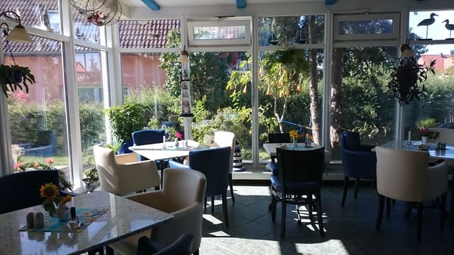 Ein Restaurant mit Tischen und Stühlen und vielen Fenstern