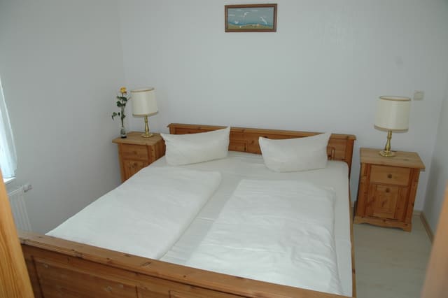 Ein Schlafzimmer mit einem Holzbett und zwei Nachttischen