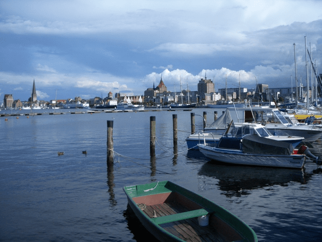 Boote liegen in einem Hafen mit einer Stadt im Hintergrund