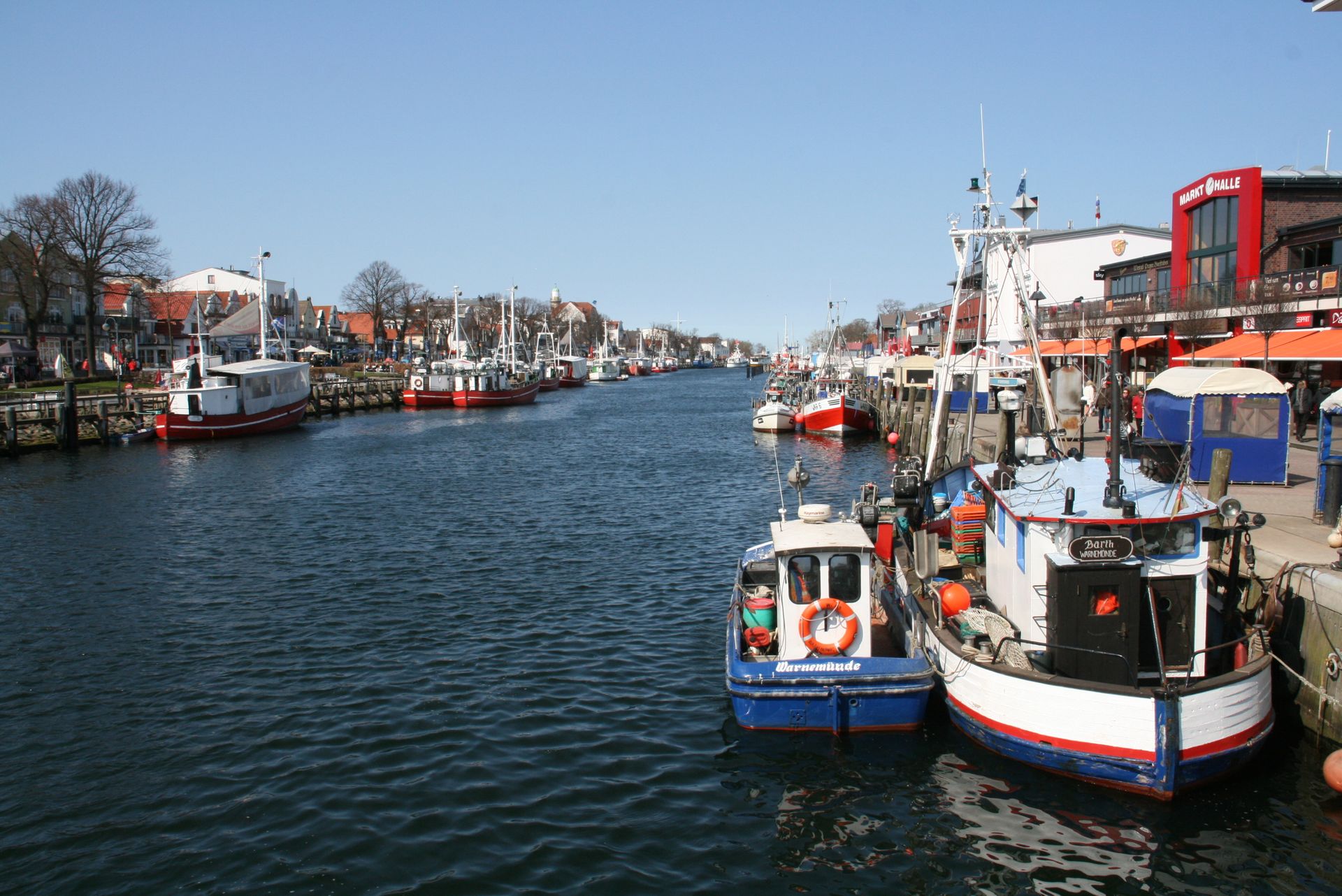 Eine Reihe von Booten liegen in einem Hafen vor Anker