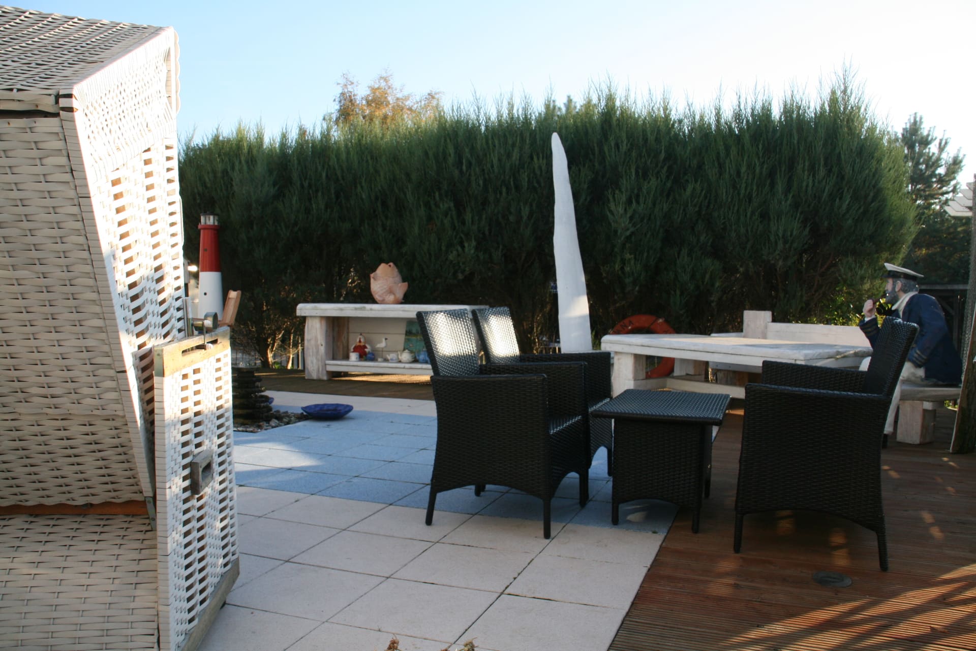 Eine Terrasse mit Korbstühlen und einem Tisch