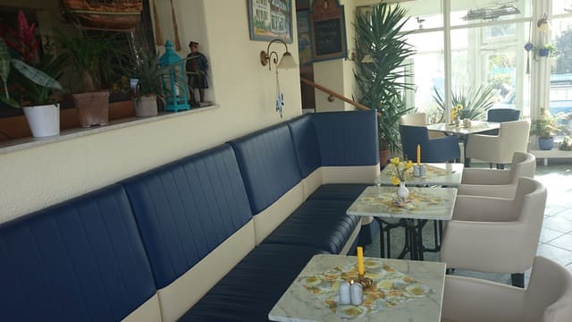 Ein Restaurant mit Tischen und Stühlen und einer Couch