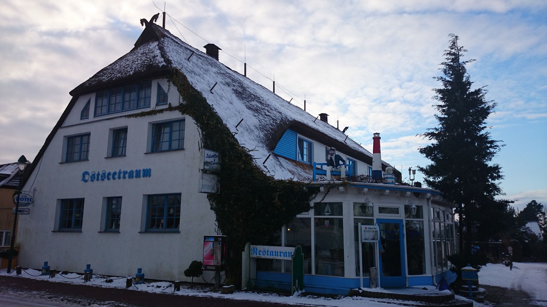 Ein weißes Gebäude mit einem blauen Schild an der Seite, auf dem 