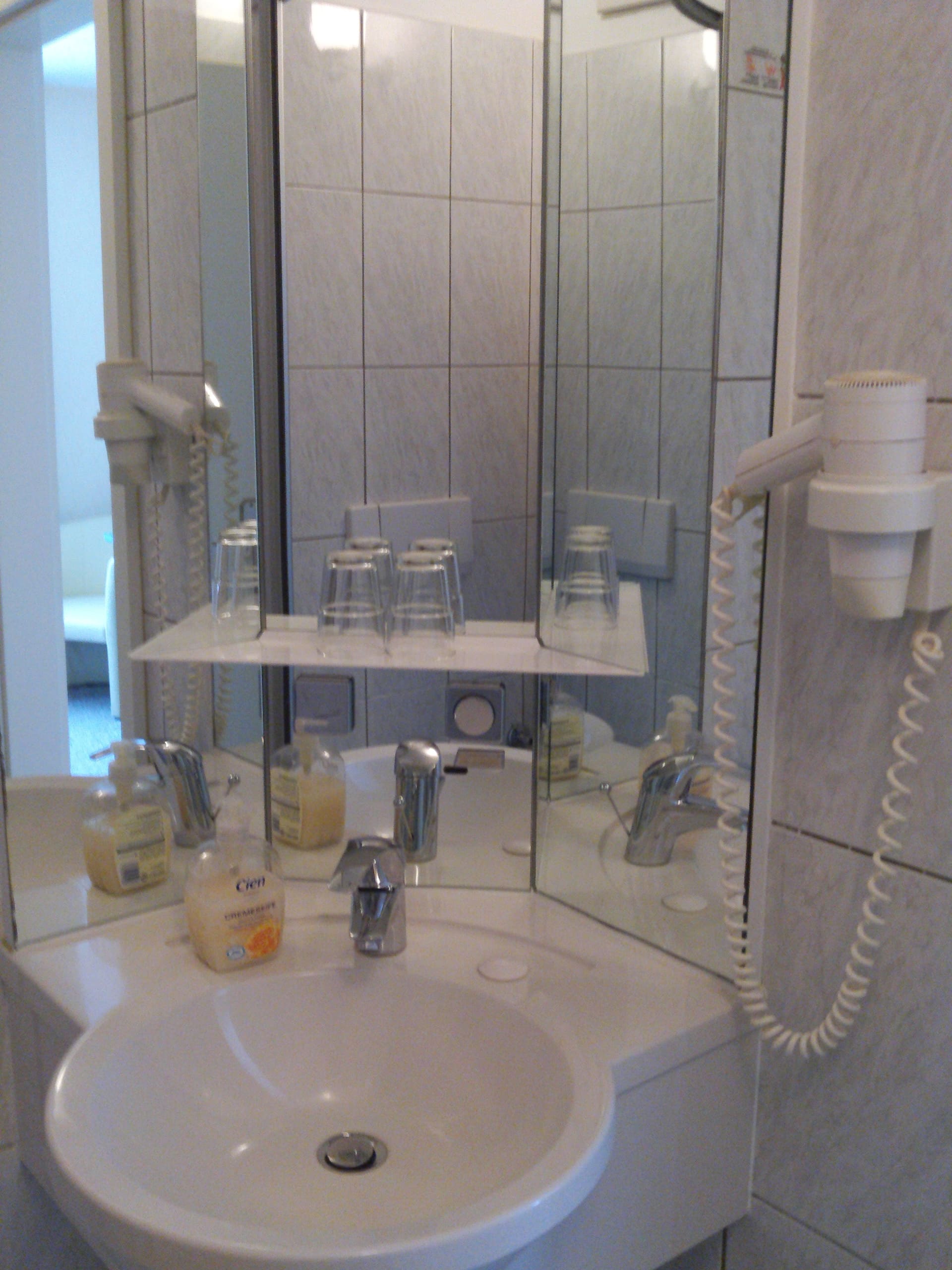 Ein Badezimmer mit Waschbecken und Haartrockner