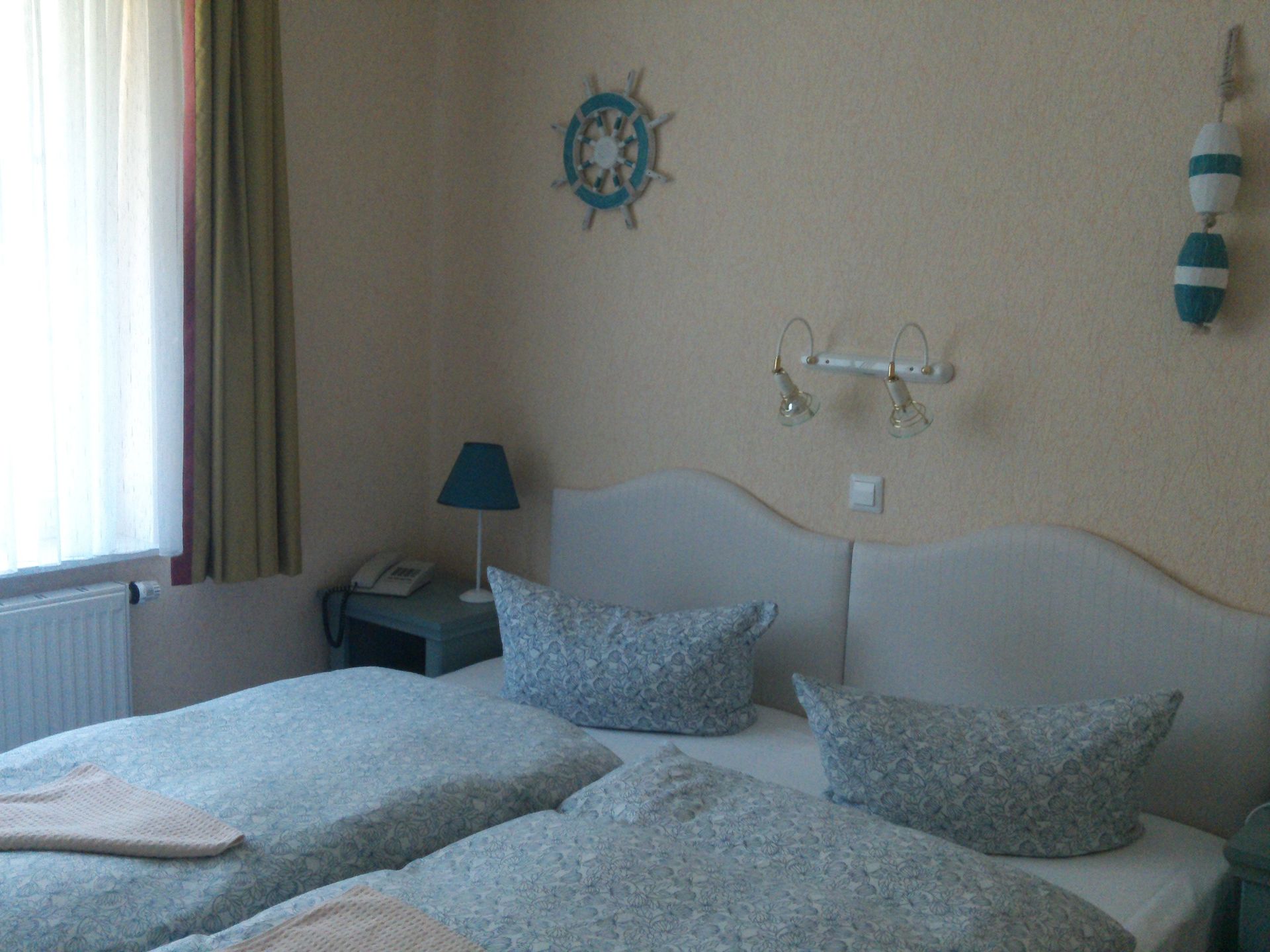 Ein Schlafzimmer mit zwei Betten und einem Lenkrad an der Wand.