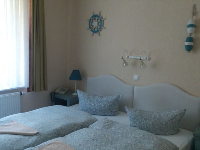 Ein Schlafzimmer mit zwei Betten und einem Lenkrad an der Wand