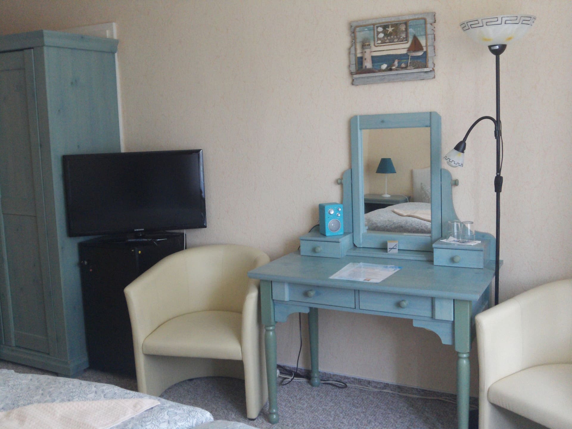 Ein Schlafzimmer mit zwei Stühlen, einem Schreibtisch und einem Fernseher