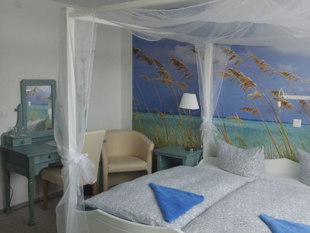 Ein Schlafzimmer mit Himmelbett und einem Bild an der Wand