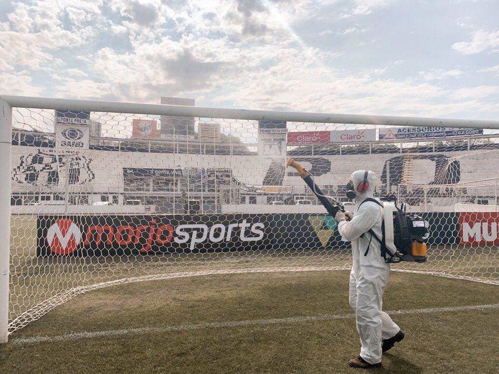 Um homem está pulverizando um gol de futebol com um pulverizador.