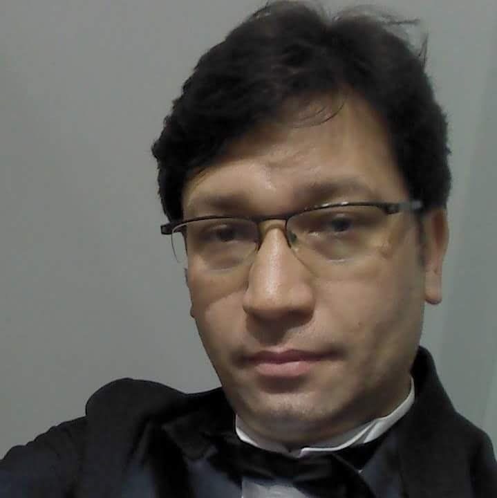 Um homem de óculos e gravata borboleta está tirando uma selfie