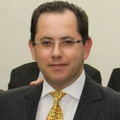 Um homem de terno e gravata posa para uma foto.