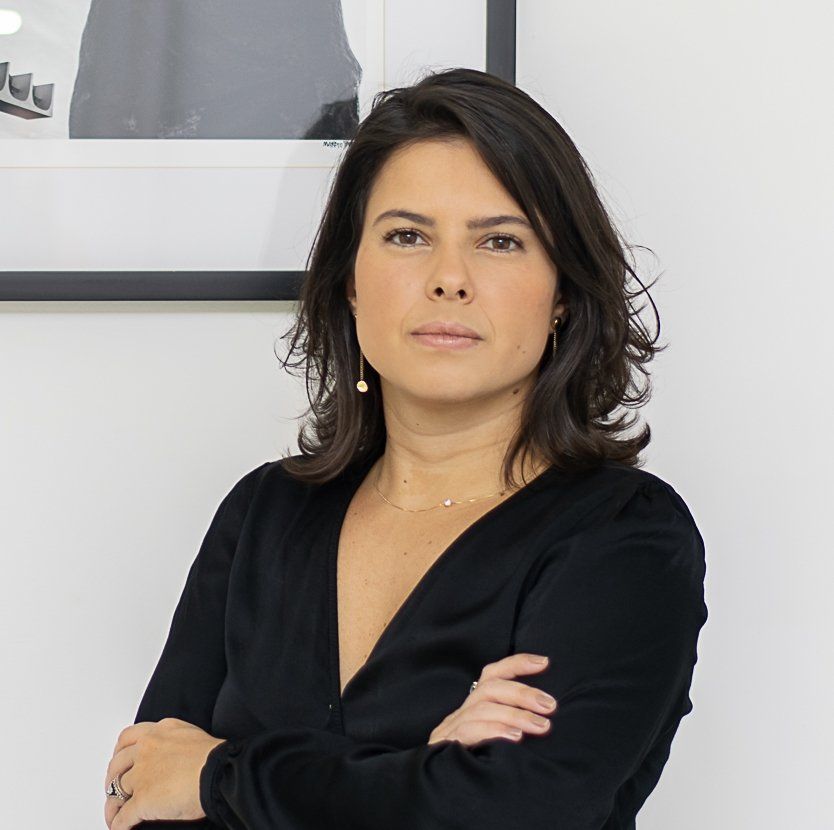 Uma mulher de camisa preta com os braços cruzados
