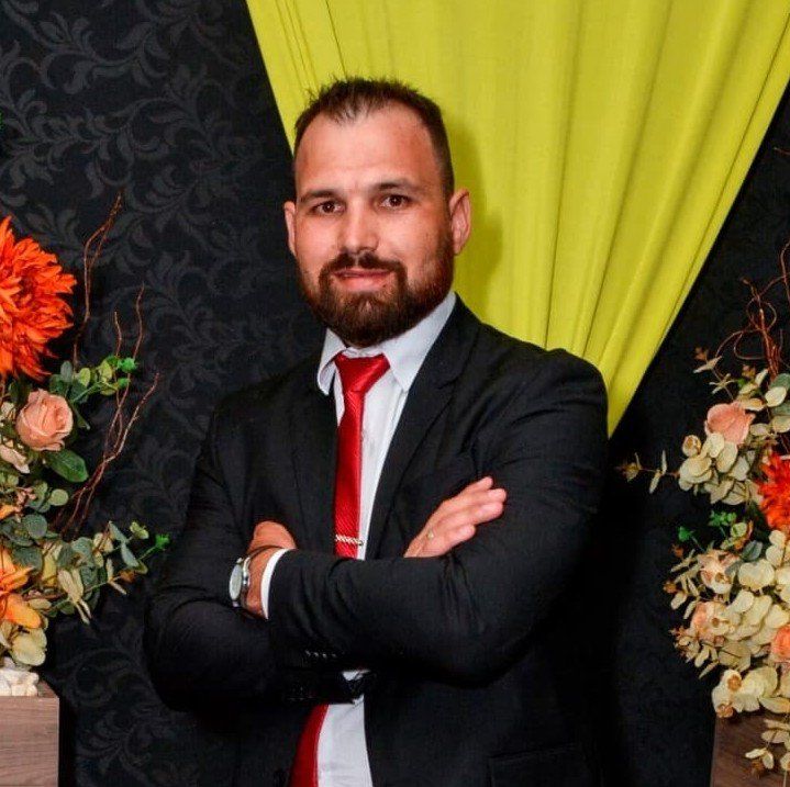 Um homem de terno e gravata com os braços cruzados