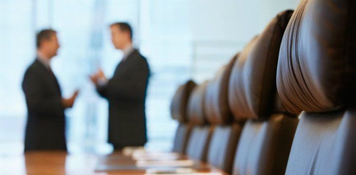 Dois homens estão em uma sala de conferências conversando entre si
