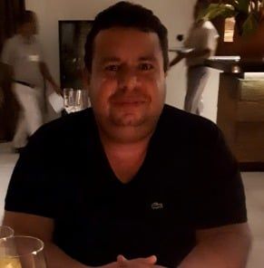Um homem vestindo uma camisa preta com o logotipo da Lacoste