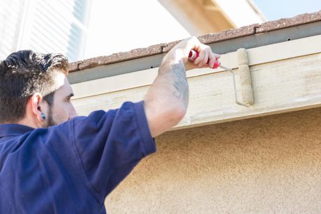 man painting the exterior wall