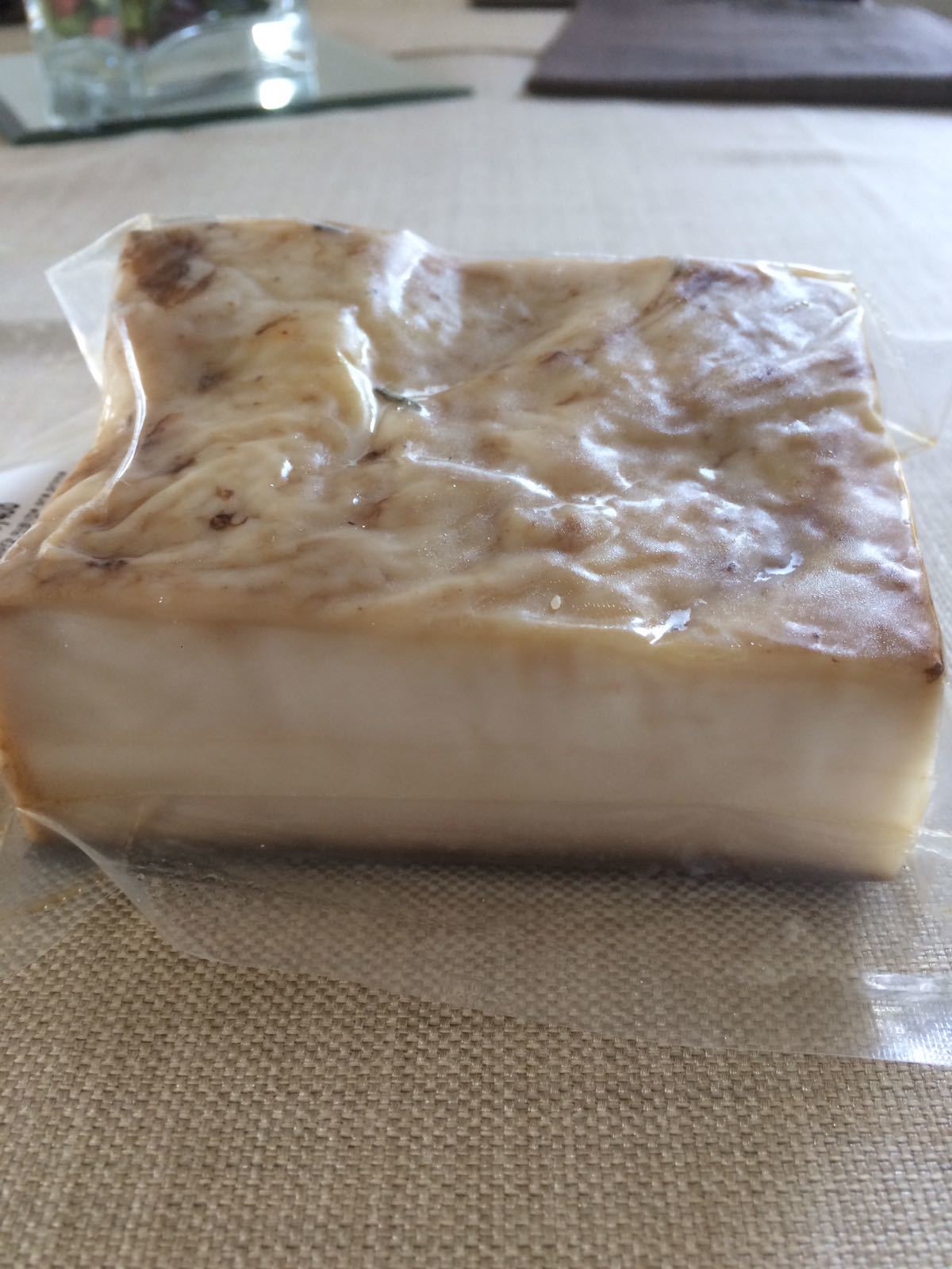 Piccolo blocco rettangolare di cibo a strati, bianco e marrone, su una tovaglia di iuta.