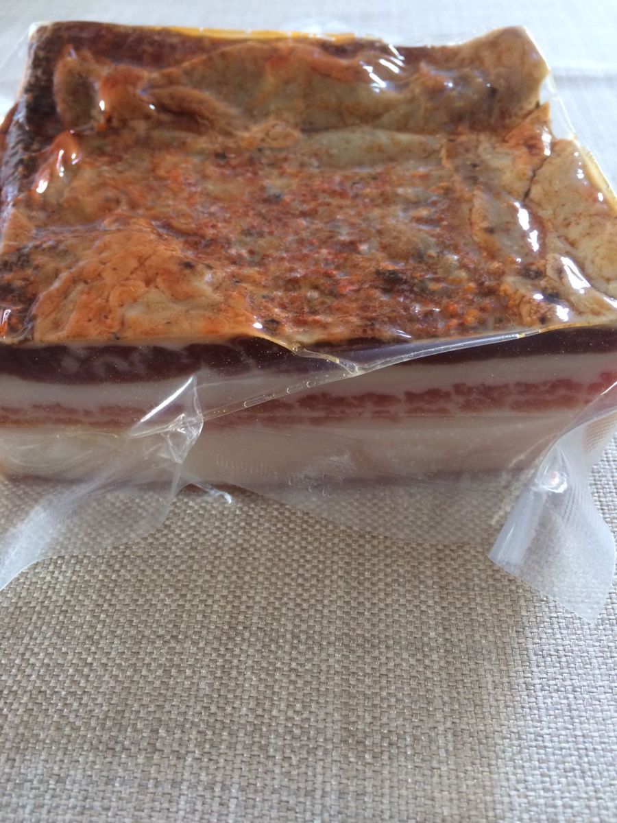 Pagnotta di carne marmorizzata o terrina avvolta in pellicola trasparente su una superficie ruvida