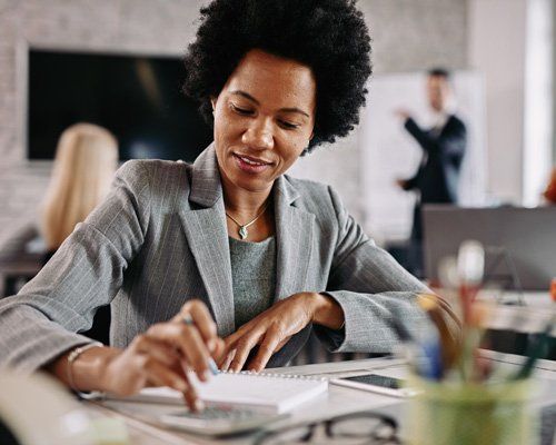 Business woman in an office looking at a notepad