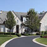 A calm residential area with a clean black road and garden areas on both sides, offering a peaceful environment