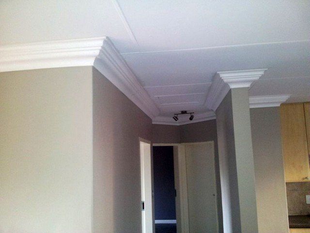 A hallway with a white ceiling and white trim