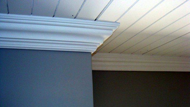A white molding on the ceiling of a room