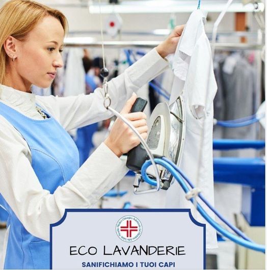 Un addetto alla lavanderia stira una camicia bianca in una lavanderia a secco con attrezzature blu e un cartello ECO LAVANDERIE.