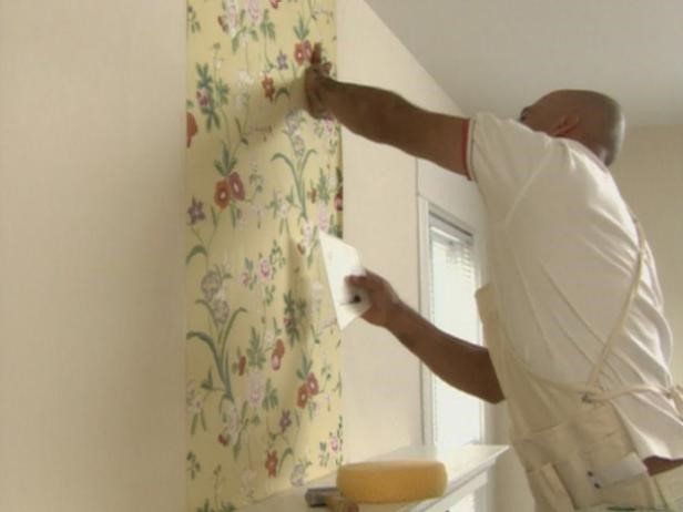 A tradesman hanging wallpaper