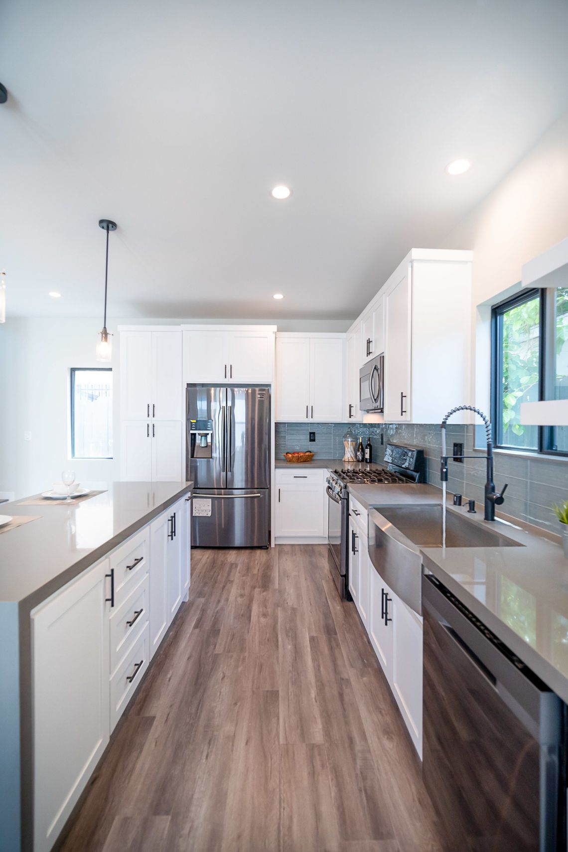 The full kitchen inside an accessory dwelling unit (ADU) backyard home, featuring plenty of space, an island, and modern all-electric appliances. 