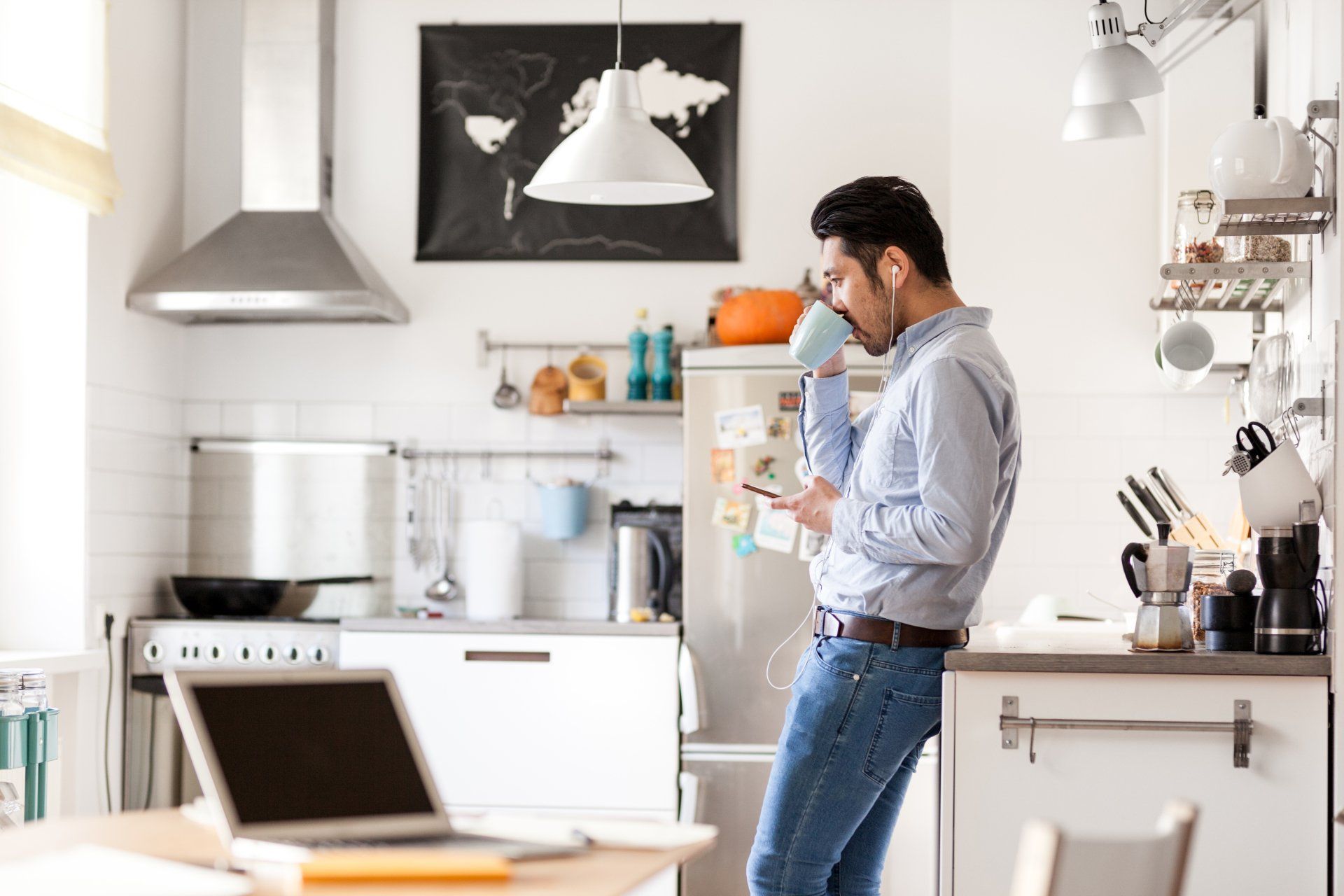 A young adult sipping coffee in the kitchen of his accessory dwelling unit (ADU); many families find an ADU useful for creating a space for adult children to live in while they save money for their own house.