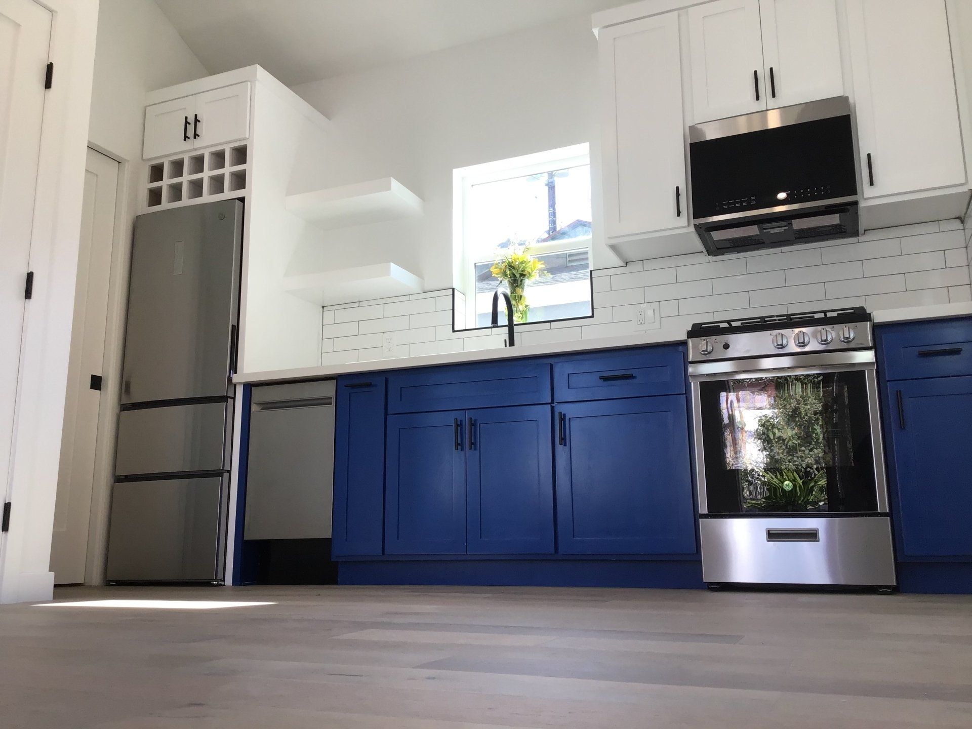 A bright and sunny efficient kitchen with shiny new appliances in an accessory dwelling unit (ADU) granny flat.