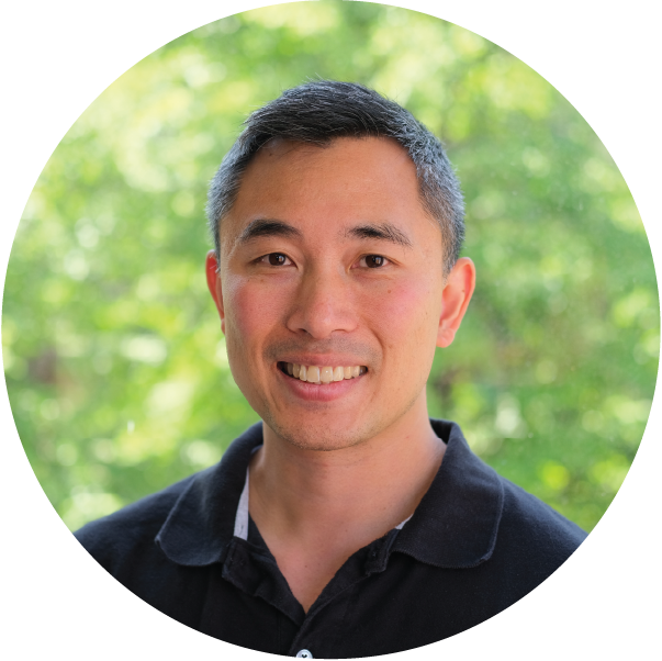 A man in a black shirt is smiling in a circle.