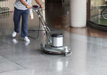 Worker cleaning the floor with polishing machine