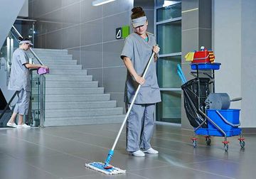 Worker with mop cleaning the floor