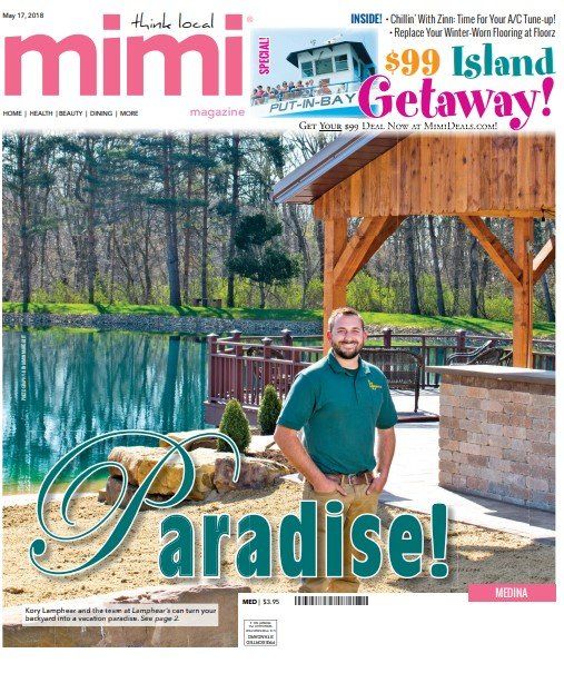 Magazine cover: Man in green shirt stands near a pond, wooden shelter in background. 
