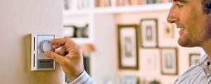 man adjusting thermostat