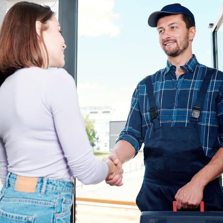 Ein Mann im karierten Hemd schüttelt einer Frau die Hand