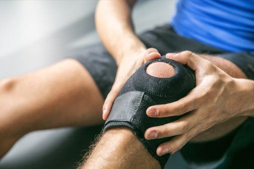 Knee and Shoulder Surgeon —  Man Holding His Knee in Lake Success, NY