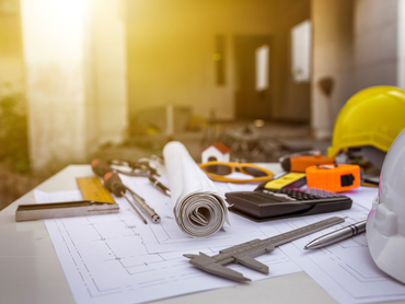 Tools and supplies scattered on blueprints