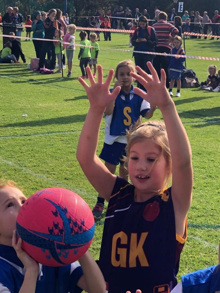 A girl in a gk jersey is holding a ball